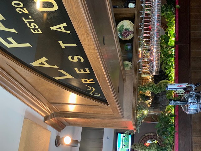 La Familia Taunton dining room bar with the carved La Familia sign overhead